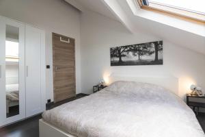 a white bedroom with a bed and a window at Les Figuiers - Appartement de Standing avec 2 Chambres in Andenne