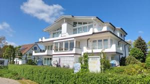 ein weißes Haus mit einem Schild davor in der Unterkunft Villa Schwan by Rujana in Binz