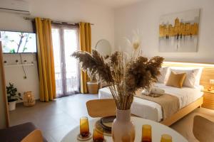 a bedroom with a bed and a table with a vase with flowers at MK Lux Suites - Steps to Beach in Agios Nikolaos