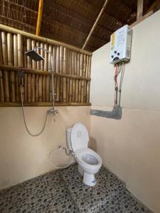 a bathroom with a toilet with a shower in it at Tangkahan Eco Glamping 