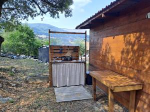 a table and a bench next to a wall at Cabane Eco Lodge in Tourrettes-sur-Loup