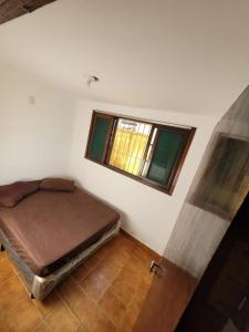 a small room with a bed and a window at Hostel Canto da Ocian in Praia Grande