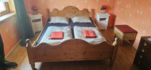 a bedroom with a wooden bed with two red pillows at Holiday home among the pearls of Norway in Stranda