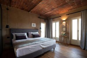 a bedroom with a large bed in a room with windows at Relais Casa Clara in Montaldo Roero