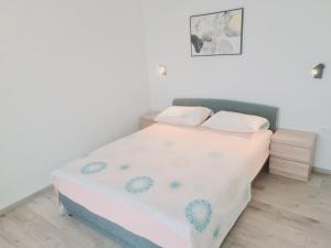 una piccola camera da letto con un letto con lenzuola bianche di Apartments Pavlić a Saplunara