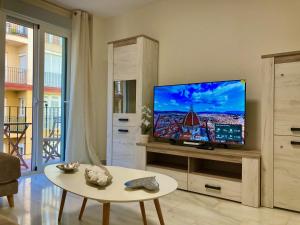 a living room with a flat screen tv on a stand at Alborán Costa del Sol in Estepona