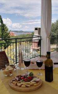 una mesa con un plato de comida y dos copas de vino en Apartments Diana, en Primošten