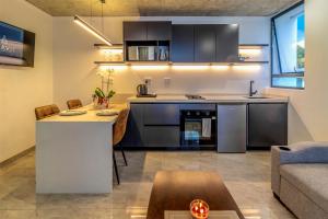 a kitchen and living room with a table and a couch at KRAVIT Premier Suites in Midrand