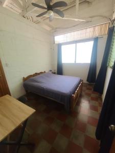 a bedroom with a bed and a ceiling fan at Hammock plantation in El Zonte +48 photos