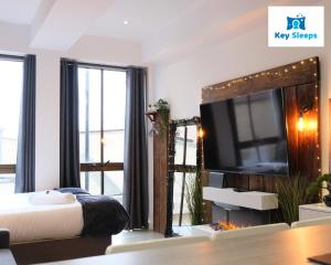 1 dormitorio con 1 cama, TV y espejo en Keysleeps Studio Apartment - Northamptonshire - Leisure & Contractors en Northampton