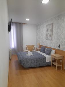 Un dormitorio con una cama y una mesa. en Salomé, en Madrid