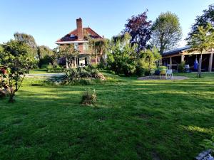 een huis in een tuin met een grasveld bij Ecolodge Tilburg Directors room and Swimmingpool in Tilburg
