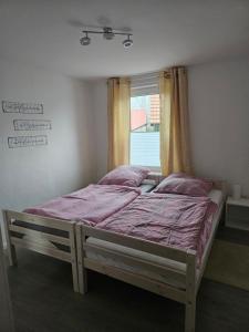 Bett in einem Zimmer mit Fenster in der Unterkunft Ferienwohnung - Stern - in Rollshausen