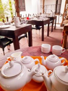 uma mesa com um monte de bules e chávenas em Heritage Rangiri Villa em Dambulla