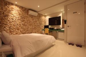 a bedroom with a bed and a brick wall at Hotel POP3 Jongno in Seoul
