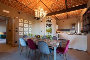 a dining room with a table and purple chairs at Relais Casa Clara in Monteu Roero
