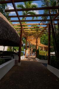 a wooden pergola with trees and palm trees at Maya Tulipanes Express in Palenque