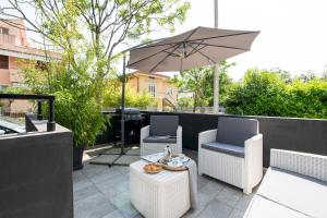 a patio with two chairs and an umbrella at La casa di Guido in Gabicce Mare