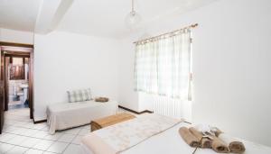 een witte kamer met 2 bedden en een raam bij Casa Vacanze Linda in Gera Lario