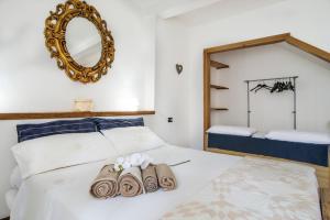 een slaapkamer met een bed met 2 handdoeken en een spiegel bij Casa Vacanze Linda in Gera Lario