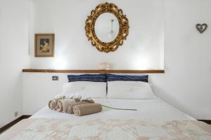 een slaapkamer met een wit bed en een spiegel bij Casa Vacanze Linda in Gera Lario