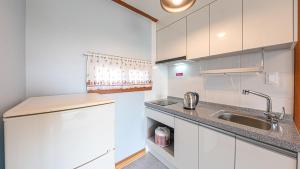a white kitchen with a sink and a counter at Eungabi Pension in Gangneung
