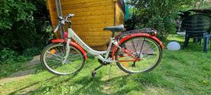 a red bike parked in the grass next to a house at Souterrainwohnung mit großem Garten und Sauna in Kassel