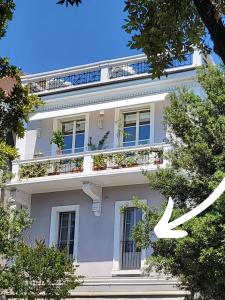 medium miramare appartamento sogno sul mare في ترييستي: مبنى ابيض عليه نوافذ ونباتات