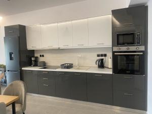 a kitchen with gray and white cabinets and appliances at Ipsos seafront in Ipsos +9 photos