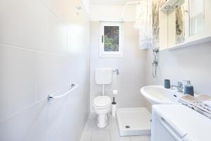 a white bathroom with a toilet and a sink at Villetta Sant'Andrea - Goelba in SantʼAndrea