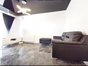 een woonkamer met een bank en een plafondventilator bij Star Aparthotel mobilat lux cu vedere la mare si parcare in Mamaia Nord – Năvodari