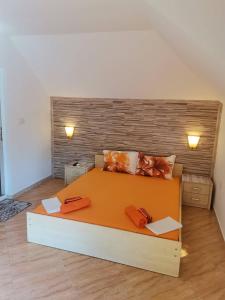 a bedroom with a large orange bed in a room at Виктория Созопол in Sozopol