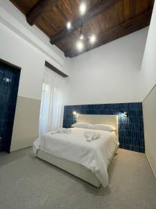 een slaapkamer met een bed met witte lakens en blauwe tegels bij La Suite del Centro Storico in Napels