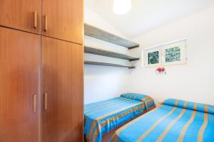 een slaapkamer met 2 bedden en een kast bij Villetta Sant'Andrea - Goelba in SantʼAndrea