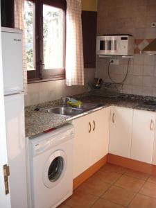 een keuken met een wastafel en een wasmachine bij APARTAMENTS PUIG GILI in Mura