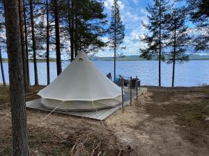 a white tent on the side of a lake at Osensjøen Camping in Valmen