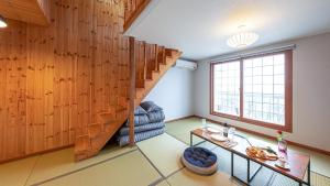 a living room with a wooden wall and a staircase at Eungabi Pension in Gangneung