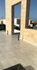 un edificio de piedra con una gran abertura en el centro en Seashell villa with private pool en El Alamein