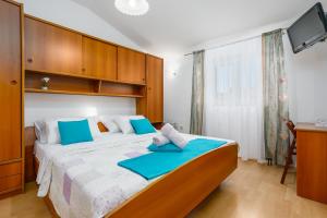 a bedroom with a large bed with blue pillows at Apartment Rukavina in Njivice