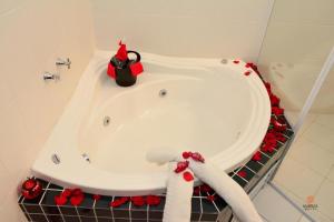 y baño con bañera decorada en rojo. en Hotel Maruá, en São José dos Campos