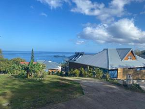 a house on a hill with the ocean in the background at Grande villa luxueuse face à la réserve Cousteau et ses tortues in Bouillante