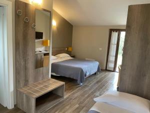 a hotel room with two beds and a mirror at Le Macerine in Castiglione del Lago