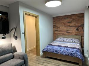 a bedroom with a bed and a brick wall at Apartament Na Wzgórzu in Iwonicz-Zdrój