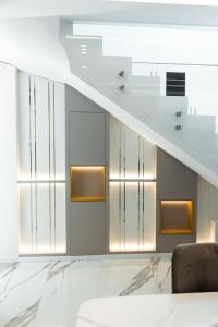 a living room with a staircase and a chair at Palmera Prive Vila in Sarandë