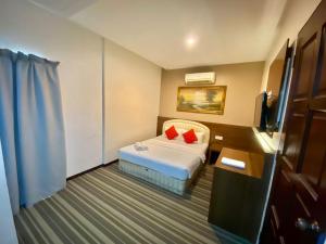 a hotel room with a bed and a desk at Rimaniz Hotel Alor Setar in Alor Setar