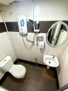 a bathroom with a toilet and a sink and a mirror at Rimaniz Hotel Alor Setar in Alor Setar