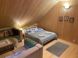 Habitación con cama y sofá en el ático en Agroturystyka Szczebra 33c Dolina Rospudy pod Augustowem, Pokoje z aneksem kuchennym en Augustów