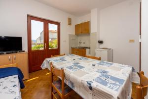 uma cozinha com uma mesa com uma toalha de mesa azul e branca em Agava em Novi Vinodolski