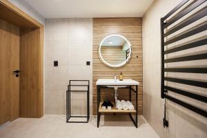 a bathroom with a sink and a mirror at EveRest Apartamenty Szczyrk in Szczyrk