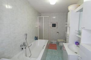 a bathroom with a tub and a sink and a toilet at Authentic stone house Rustica near Makarska Riviera in Lovreć